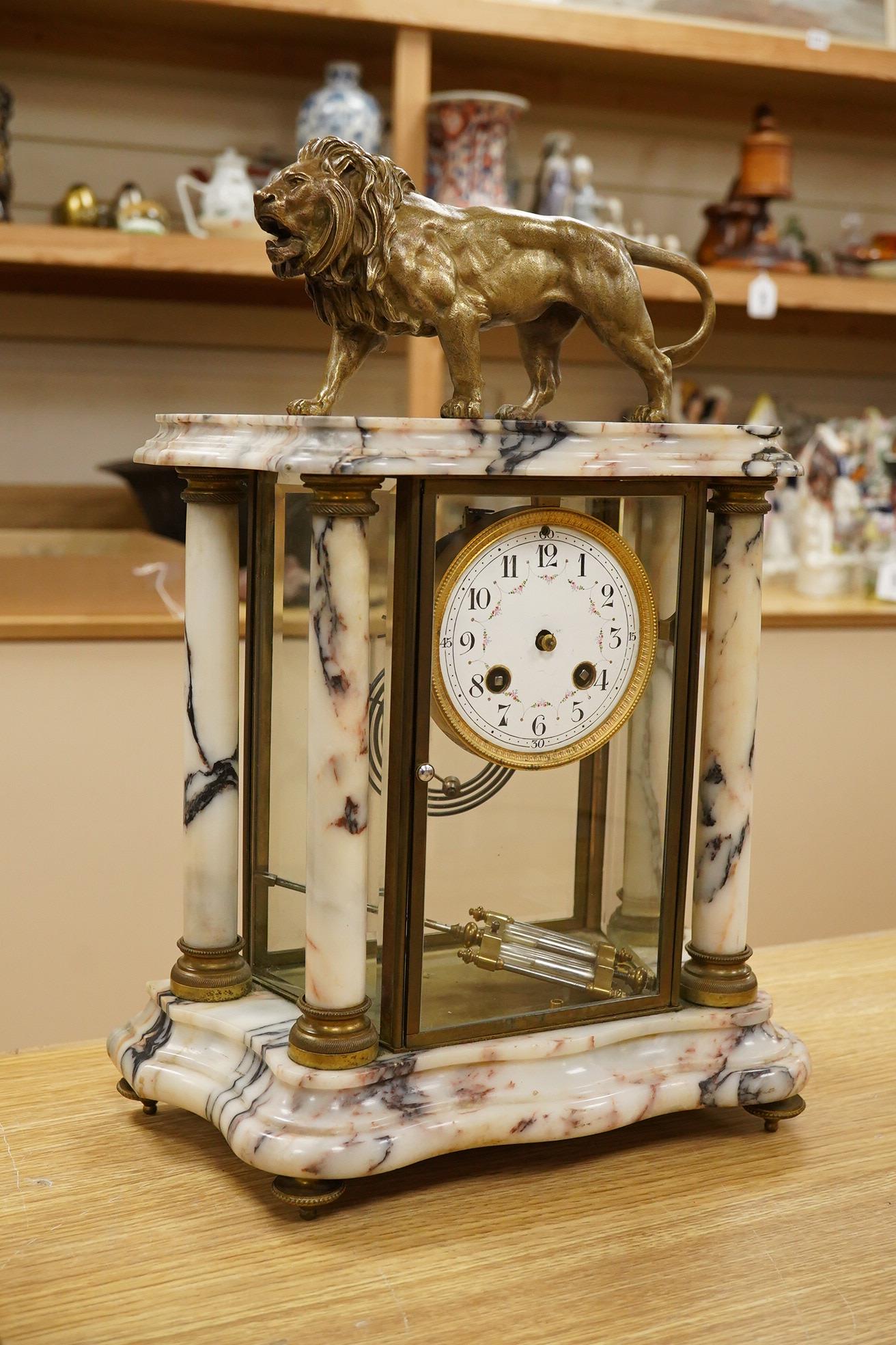 An early 20th century marble mantel clock with lion surmount, with pendulum, 39cm high